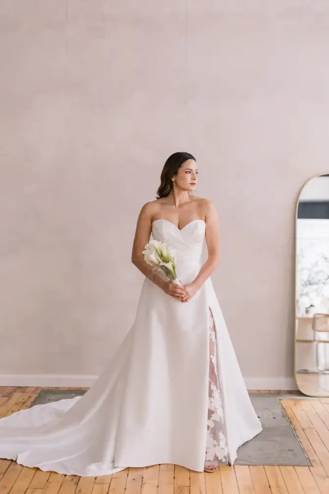 Model is wearing a strapless silk mikado wedding dress with a sweetheart neckline
