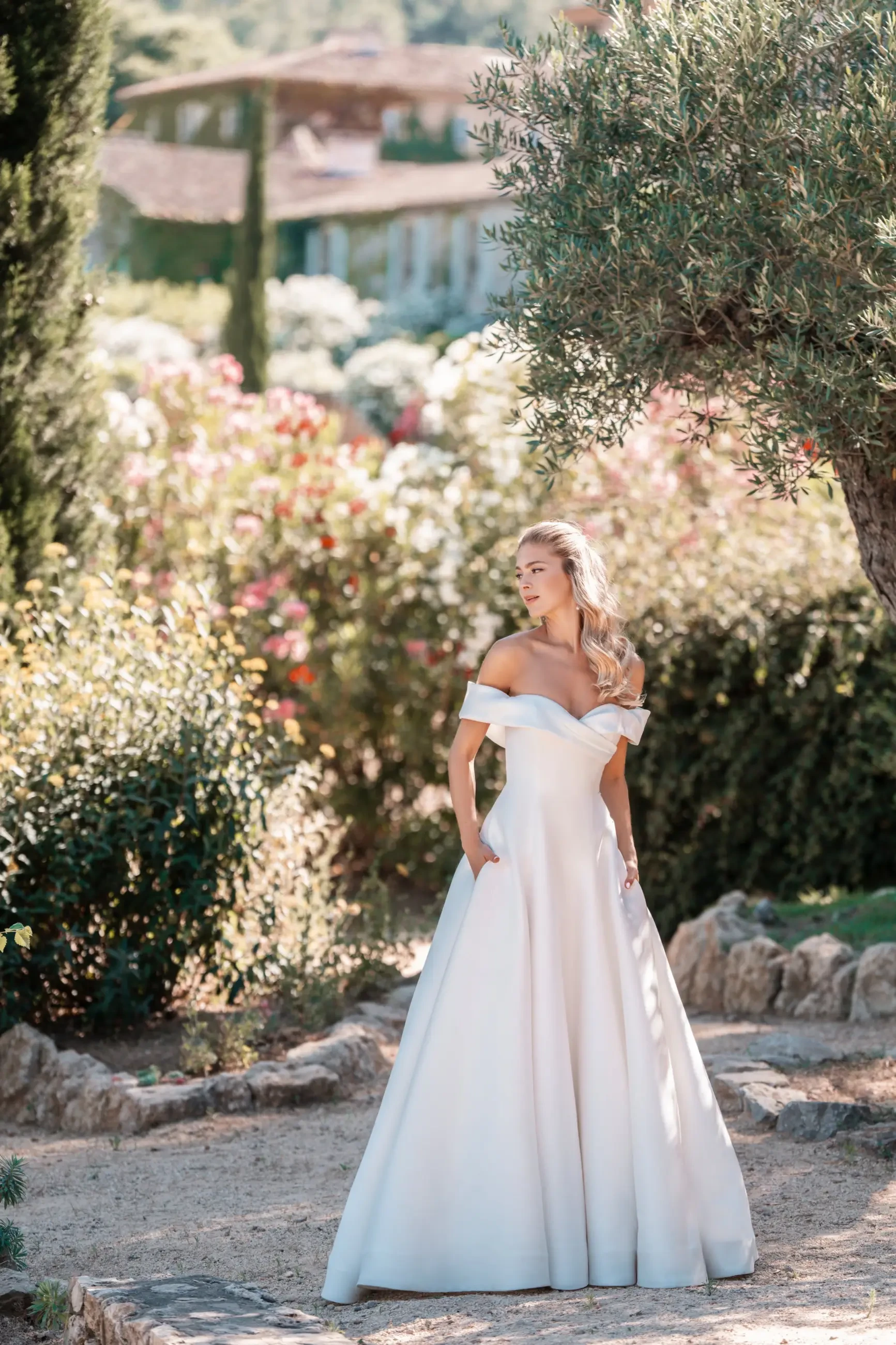 model is wearing an off the shoulder a-line bridal gown by allure bridals