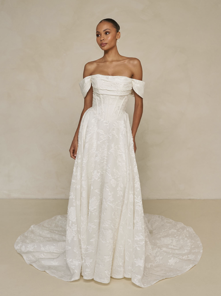 model is wearing an off the shoulder a-line wedding gown