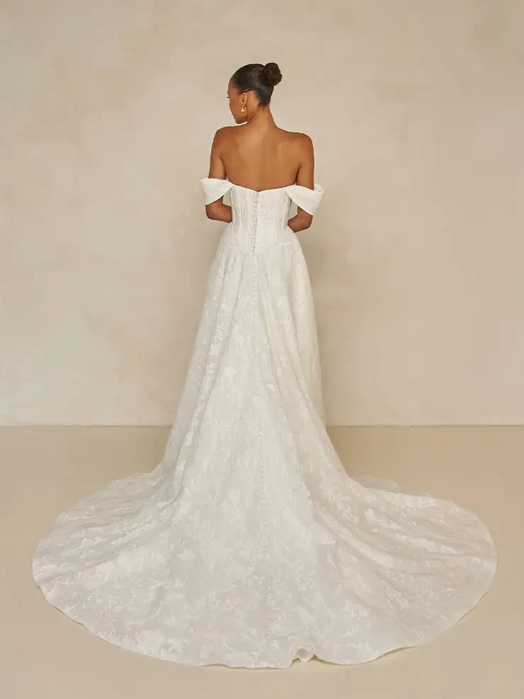 model is wearing an off the shoulder a-line wedding gown