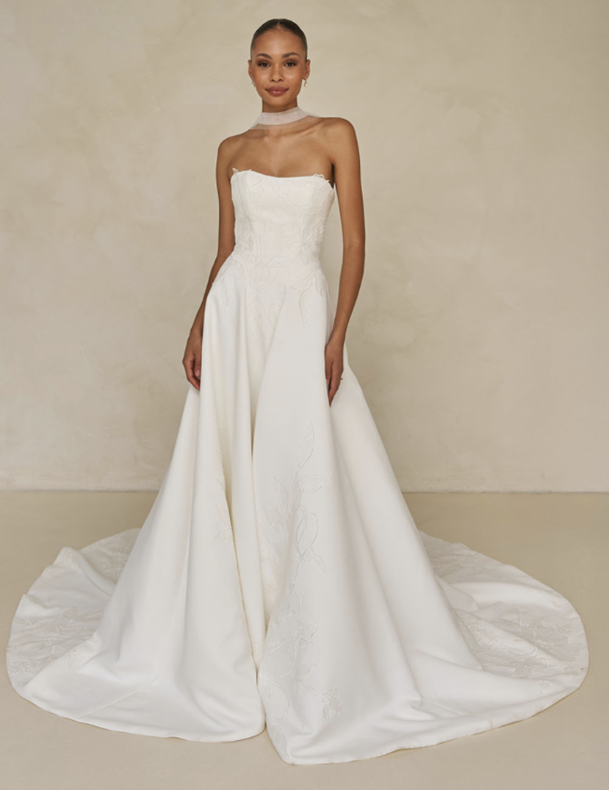 model is wearing a strapless bridal gown with a bridal scarf