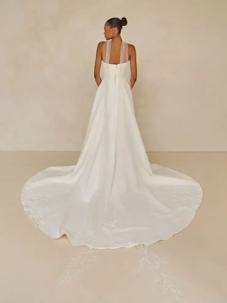 model is wearing a strapless bridal gown with a bridal scarf