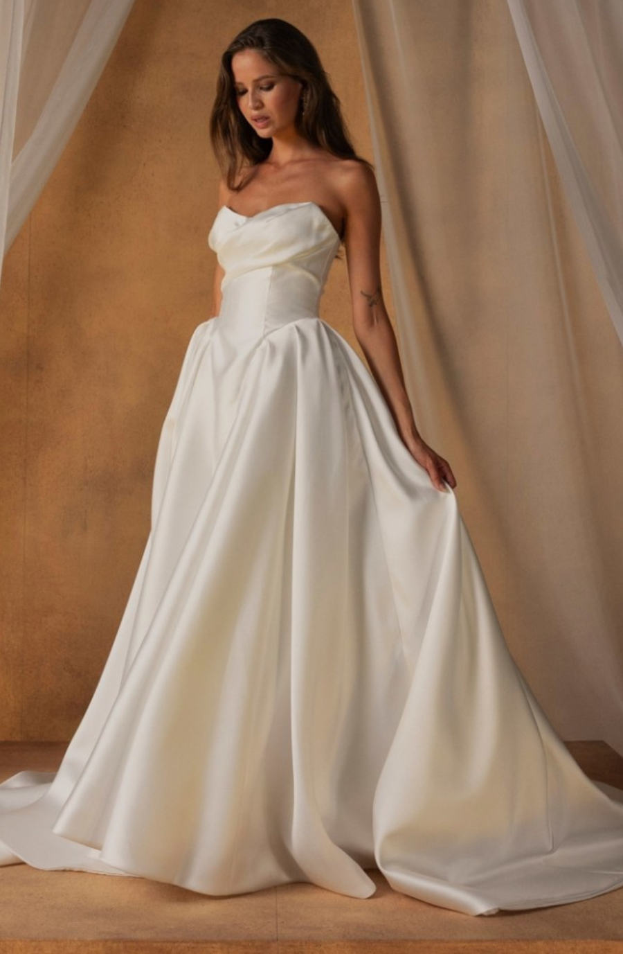 model is wearing a strapless ball gown