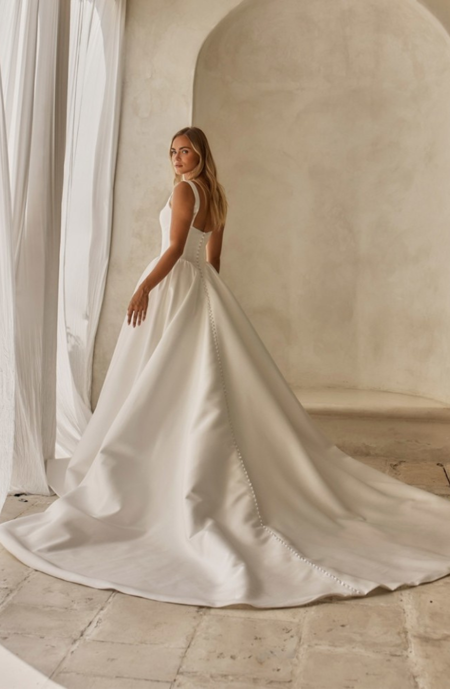 model is wearing a sleeveless a-line bridal gown