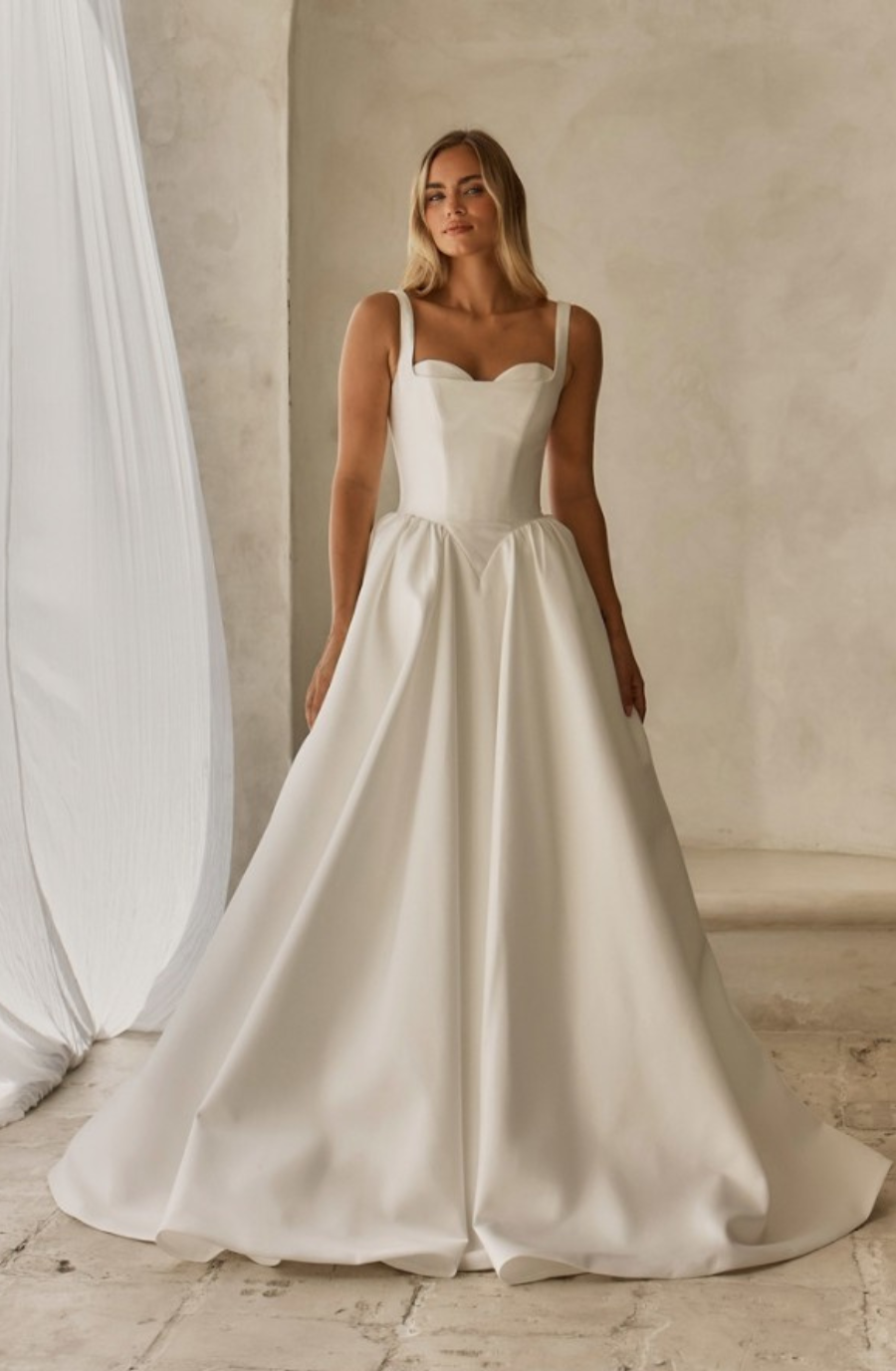 model is wearing a sleeveless a-line bridal gown