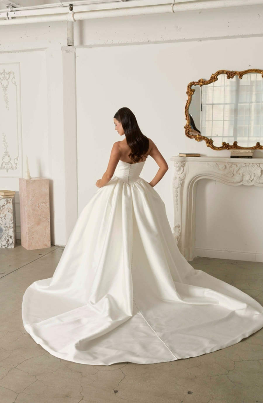 model is wearing a strapless ball gown wedding dress