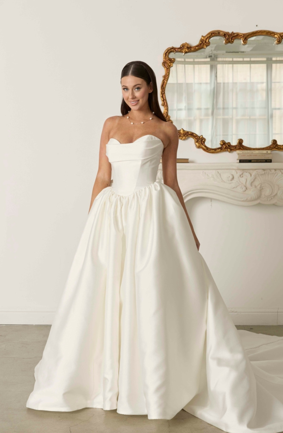 model is wearing a strapless ball gown wedding dress